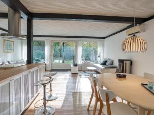 een keuken en een woonkamer met een tafel en stoelen bij Holiday home Gilleleje XCI in Gilleleje