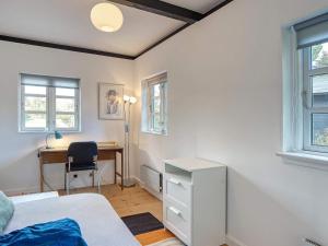 1 dormitorio con 1 cama, escritorio y ventanas en Holiday home Gilleleje XCI, en Gilleleje
