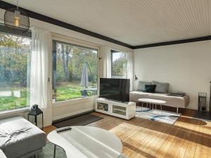 een woonkamer met een bank en een flatscreen-tv bij Holiday home Gilleleje XCI in Gilleleje