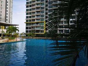 a swimming pool in front of a tall building at Parc Regency Green Homestay By Easyhomestay in Johor Bahru
