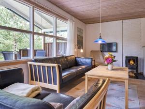 a living room with a couch and a table at Holiday home Aakirkeby XXXIX in Vester Sømarken