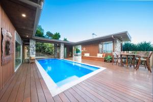 a house with a swimming pool on a wooden deck at Holiday Haven Whitsundays in Cannon Valley