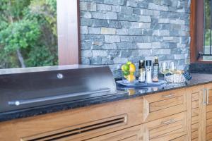 a counter with a counter top with bottles of wine at Holiday Haven Whitsundays in Cannon Valley