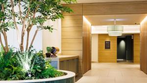 a hallway with a tree in the middle of a building at JR-East Hotel Mets Omori in Tokyo