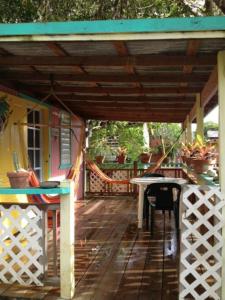 porche de madera con mesa y toldo en Naniqui Cottage - Only Adults Relax - Only Parking Golf Car, en Culebra