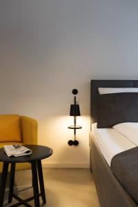 um quarto com uma cama, uma mesa e um candeeiro em Square Rooms 8 em Dusseldorf