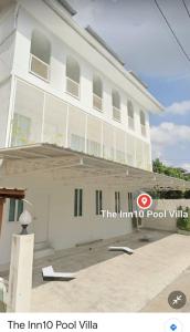 芭達雅中心的住宿－The Inn10 Pool Villa Pattaya, Entire Villa, 9 Bedrooms, Private Indoor Swimming Pool, ดิ อินน์เท็น，一座白色的建筑,设有信息泳池别墅