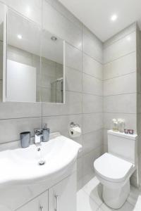 a white bathroom with a toilet and a sink at City Sparrow Nest - 2W in London