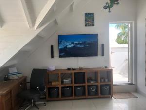 マリゴにあるDeja Blue - Comfortable Beachfront condoのリビングルーム(テレビ、椅子付)