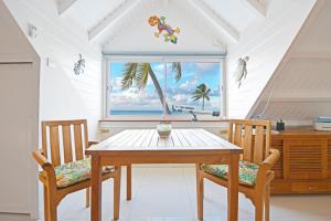 comedor con mesa, 2 sillas y ventana en Deja Blue - Comfortable Beachfront condo, en Marigot