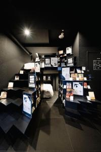 BOOK HOTEL 神保町 في طوكيو: غرفه فيها عدة رفوف عليها صور