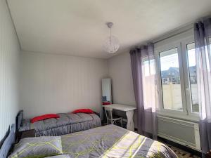 um quarto com uma cama, uma janela e uma secretária em Maison Jullouville, 3 pièces, 5 personnes - FR-1-361-334 em Jullouville-les-Pins