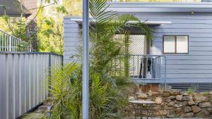 a house with a garden with a table and a fence at Studio 21 in Nelson Bay