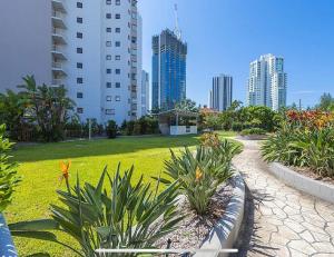 a walkway in a park in a city with tall buildings at Broadbeach Travel Inn Apartments in Gold Coast