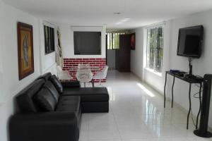 a living room with a couch and a tv at Backyard loft in the heart of the forest in Salento