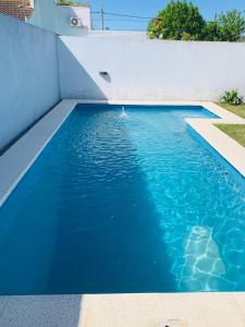 una piscina de agua azul en una casa en LOS SAUCES CHASCOMUS en Chascomús