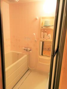 a bathroom with a bath tub and a sink at 【那須高原の自然に囲まれたログハウス1棟貸し】ファミリー利用、大人数での利用、パーティも大歓迎！ in Nasu-yumoto