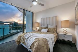 - une chambre avec un grand lit et un balcon dans l'établissement Stunning Waterfront Penthouse 3 or 4 Bedrooms, à Brisbane