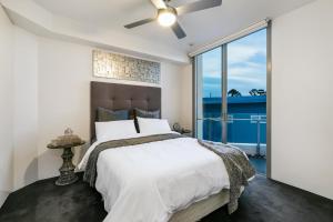 a bedroom with a bed and a large window at Stunning Waterfront Penthouse 3 or 4 Bedrooms in Brisbane