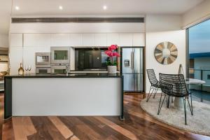 a kitchen with a counter and two chairs and a table at Stunning Waterfront Penthouse 3 or 4 Bedrooms in Brisbane