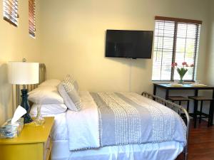 Casita Alkie في ليتشفيلد بارك: غرفة نوم مع سرير وتلفزيون على الحائط