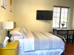 a bedroom with a bed with a tv on the wall at Casita Alkie in Litchfield Park