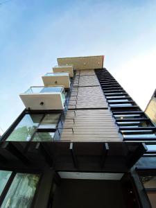 a tall building with glass windows on top of it at UNWND Flats in Manila