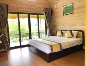a bedroom with a bed in a room with windows at Nasan Green Farm in Cao Bằng
