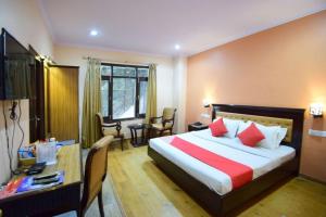 a hotel room with a bed and a desk and a room at Goroomgo Marc Shimla Near Mall Road - Luxury Room - Excellent Service - Ample Parking - Best Hotel in Shimla in Shimla