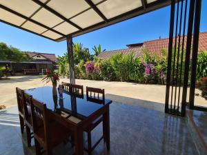 a table with chairs and a vase on top of it at Saphaothong guesthouse in Vang Vieng