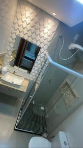 ein Badezimmer mit Waschbecken, Spiegel und Toilette in der Unterkunft Apartamento Duplex - a 3 min da Praia apé, Próximo Axé Moi e ToaToa in Porto Seguro