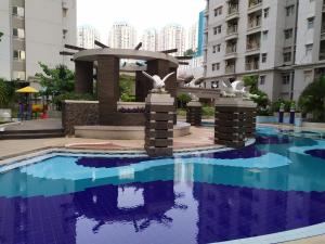 a fountain in the middle of a pool in a building at Classy! 2BR Medit2 West Jakarta in Jakarta