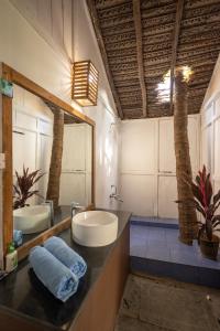 a bathroom with two sinks and a large mirror at Forget Me Not Resort in Agonda