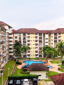a large apartment complex with a swimming pool and parking lot at D'Mentari Laguna Super Seaview in Port Dickson