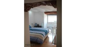 リスボンにあるDreaming Lisbon - Trigueirosの窓付きの部屋にベッド付きのベッドルーム1室があります。