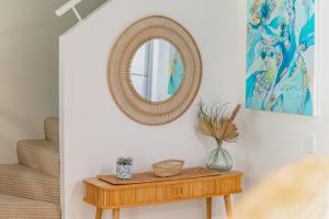 einen Spiegel an einer Wand über einem Holztisch in der Unterkunft Modern & Stylish 2 Bedroom Townhouse in Noosaville + 24 Fotos