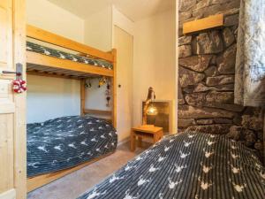ein Schlafzimmer mit einem Etagenbett und einer Steinmauer in der Unterkunft Charmant 2 pièces à Valmorel avec balcon, linge de lit et ménage inclus, 4 pers. - FR-1-291-879 in Valmorel