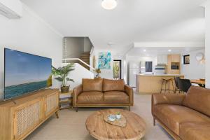 a living room with a large flat screen tv at Modern & Stylish 2 Bedroom Townhouse in Noosaville