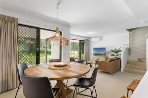 a dining room and living room with a table and chairs at Modern & Stylish 2 Bedroom Townhouse in Noosaville