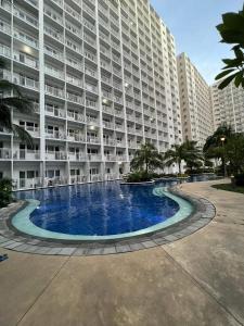 a large apartment building with a large swimming pool at Yam Staycation Shore Residences in Manila