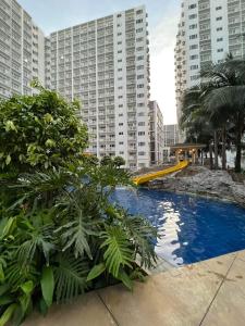 a swimming pool in a city with tall buildings at Yam Staycation Shore Residences in Manila