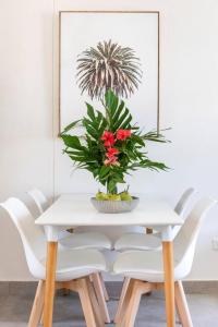 a white dining room table with a flower arrangement on it at 'Botanica Fresca' Chic Nightcliff Convenience in Nightcliff