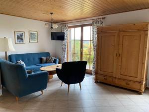 a living room with a blue couch and a table at Holiday home in the Kn llgebirge with balcony in Neuenstein