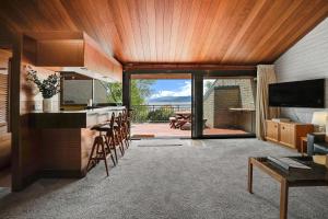 a kitchen and living room with a view of a patio at Grey Kangaroo On Lake Jindabyne foreshore in Jindabyne