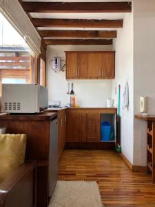 a kitchen with wooden cabinets and a wooden floor at Quito Downtown View Point Studio in Quito