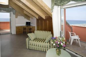 uma sala de estar com um sofá e uma mesa com flores em Hotel Lido em Deiva Marina