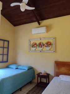 um quarto com 2 camas e uma ventoinha de tecto em Recanto dos Pássaros em Ilhabela