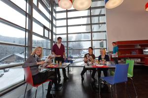 eine Gruppe von Personen, die in einem Restaurant an Tischen sitzen in der Unterkunft Hotel Zauberberg in Semmering