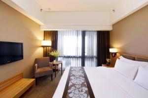 a hotel room with a large bed and a television at Fullon Hotel Hualien in Hualien City