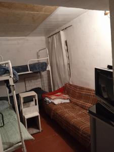 a room with a couch and a tv and bunk beds at hostel Mrganush in Meghri